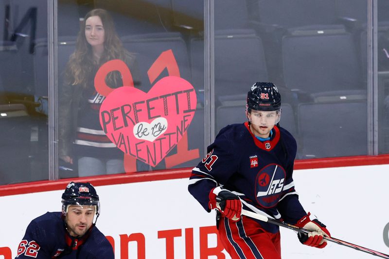 Feb 14, 2024; Winnipeg, Manitoba, CAN; Winnipeg Jets center Cole Perfetti (91) skates past a fan before a game against the San Jose Sharks at Canada Life Centre. Mandatory Credit: James Carey Lauder-USA TODAY Sports