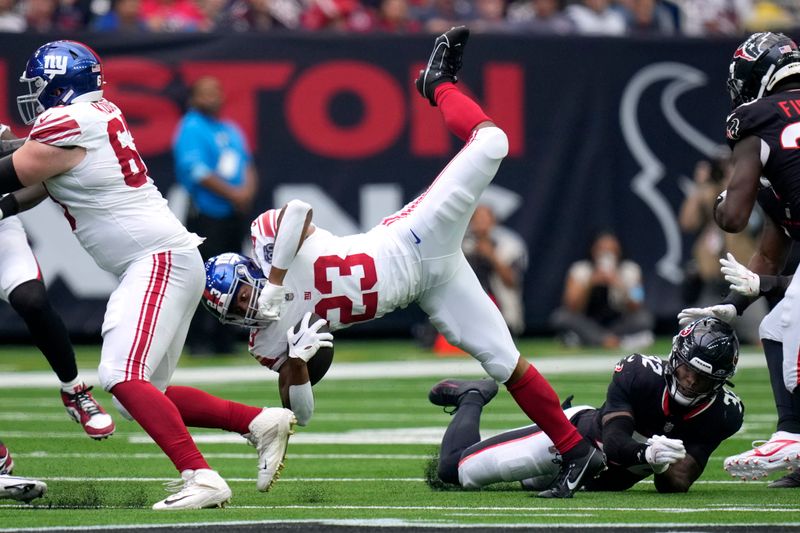 New York Giants' Tre Herndon (23) is upended by Houston Texans safety Lonnie Johnson Jr. (32) as he carries the ball in the second half of a preseason NFL football game, Saturday, Aug. 17, 2024, in Houston. (AP Photo/Eric Gay)