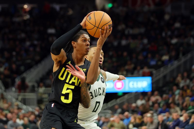 MILWAUKEE, WISCONSIN - NOVEMBER 07: Cody Williams #5 of the Utah Jazz is defended by Damian Lillard #0 of the Milwaukee Bucks during the second half of a game at Fiserv Forum on November 07, 2024 in Milwaukee, Wisconsin.  NOTE TO USER: User expressly acknowledges and agrees that, by downloading and or using this photograph, User is consenting to the terms and conditions of the Getty Images License Agreement. (Photo by Stacy Revere/Getty Images)