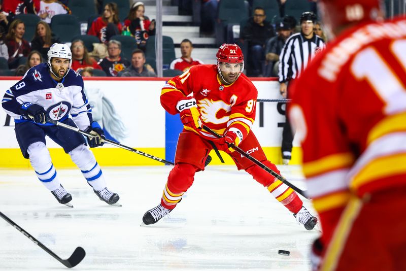 Oct 4, 2024; Calgary, Alberta, CAN; Calgary Flames center Nazem Kadri (91) controls the puck against the Winnipeg Jets during the second period at Scotiabank Saddledome. Mandatory Credit: Sergei Belski-Imagn Images