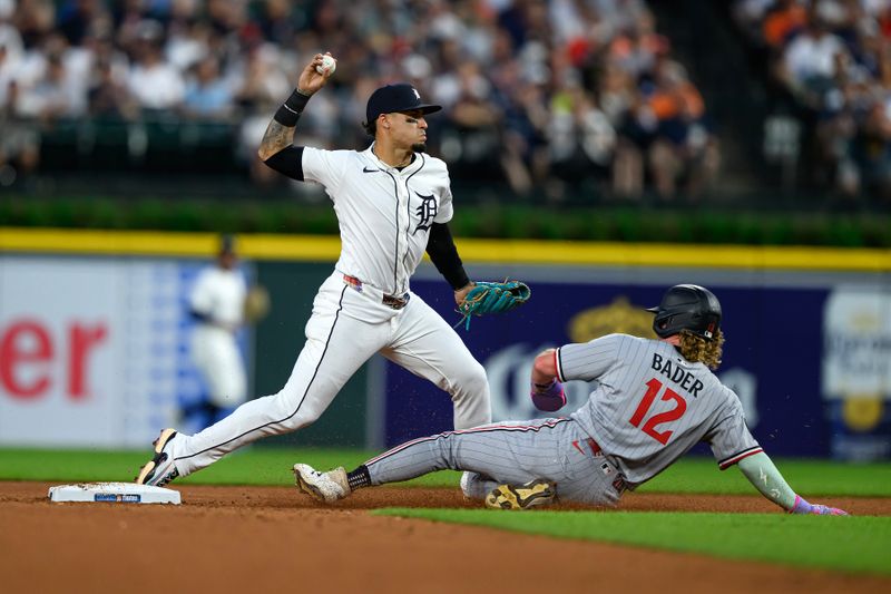 Jun 29, 2025; Detroit, Michigan, USA; Detroit Tigers shortstop Javier Báez (28) turns a double play over Minnesota Twins left fielder Harrison Bader (12) in the eighth inning at Comerica Park. Mandatory Credit: Lon Horwedel-Imagn Images