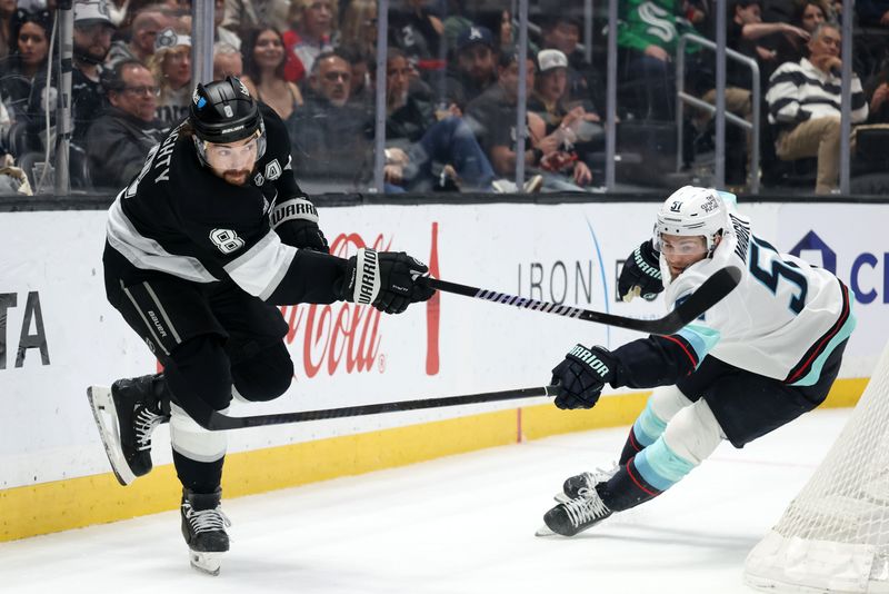 Feb 4, 2026; Los Angeles, California, USA;  Los Angeles Kings defenseman Drew Doughty (8) passes the puck against Seattle Kraken center Shane Wright (51) during the first period at Crypto.com Arena. Mandatory Credit: Kiyoshi Mio-Imagn Images