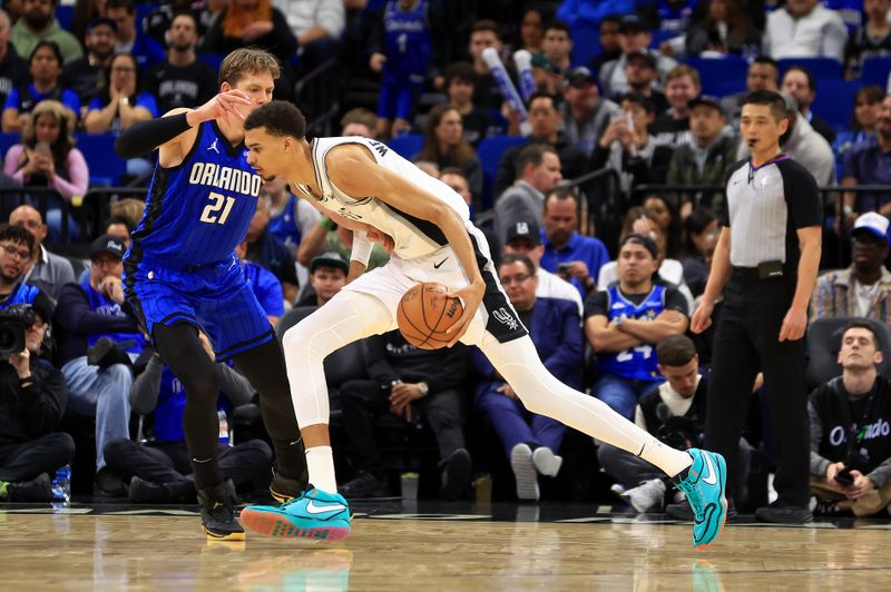 ORLANDO, FLORIDA - FEBRUARY 08: Victor Wembanyama #1 of the San Antonio Spurs drives on  Moritz Wagner #21 of the Orlando Magic during a game  at Kia Center on February 08, 2024 in Orlando, Florida. (Photo by Mike Ehrmann/Getty Images) NOTE TO USER: User expressly acknowledges and agrees that, by downloading and or using this photograph, User is consenting to the terms and conditions of the Getty Images License Agreement. (Photo by Mike Ehrmann/Getty Images)