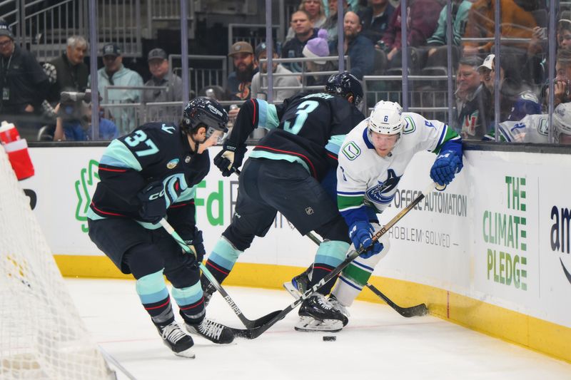 Feb 22, 2024; Seattle, Washington, USA; Vancouver Canucks right wing Brock Boeser (6) plays the puck off the wall while defended by Seattle Kraken center Yanni Gourde (37) and Seattle Kraken defenseman Will Borgen (3) during the first period at Climate Pledge Arena. Mandatory Credit: Steven Bisig-USA TODAY Sports