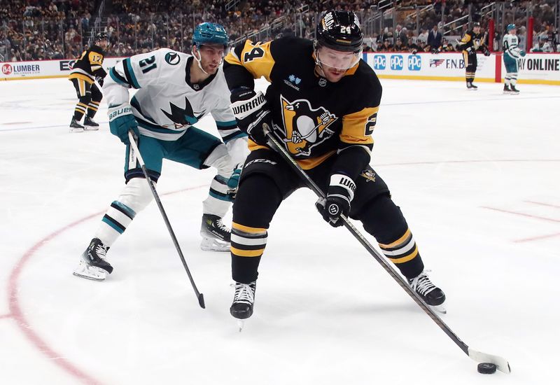 Nov 16, 2024; Pittsburgh, Pennsylvania, USA;  Pittsburgh Penguins defenseman Matt Grzelcyk (24) chases the puck ahead of San Jose Sharks center Alexander Wennberg (21) during the second period  at PPG Paints Arena. Mandatory Credit: Charles LeClaire-Imagn Images