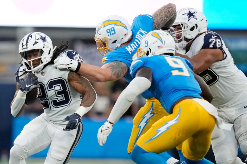 Dallas Cowboys running back Rico Dowdle (23) gets around the tackle attempt by Los Angeles Chargers defensive tackle Scott Matlock (99) during the first half of an NFL football game Monday, Oct. 16, 2023, in Inglewood, Calif. (AP Photo/Ashley Landis)