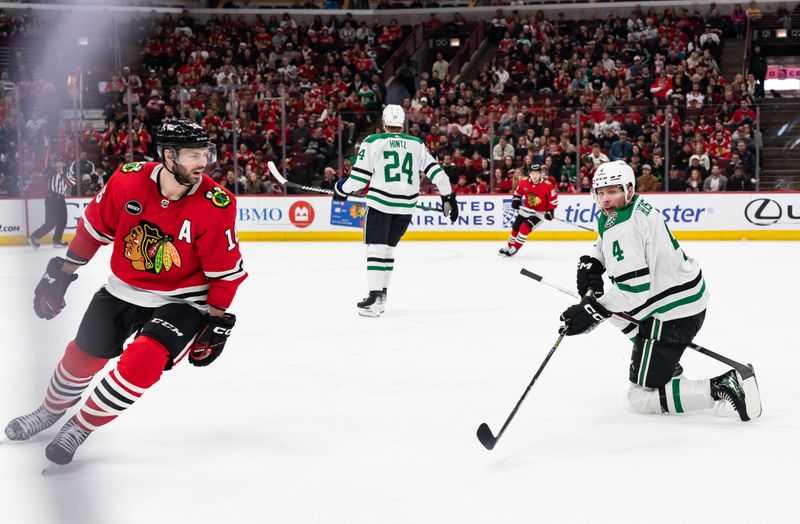 Apr 6, 2024; Chicago, Illinois, USA; Play pauses as Dallas Stars defenseman Miro Heiskanen (4) holds Chicago Blackhawks center Jason Dickinson's (16) stick during the third period period at United Center. Mandatory Credit: Seeger Gray-USA TODAY Sports