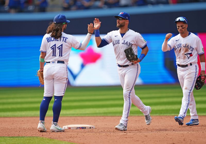 Jul 16, 2023; Toronto, Ontario, CAN; Toronto Blue Jays shortstop Bo Bichette (11) and center fielder Kevin Kiermaier (39) celebrate the win at the end of the ninth inning against the Arizona Diamondbacks at Rogers Centre. Mandatory Credit: Nick Turchiaro-USA TODAY Sports