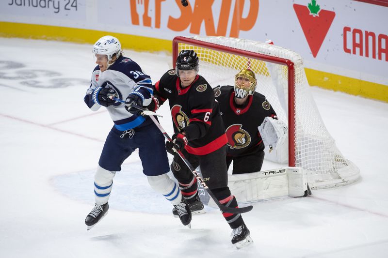 Jan 20, 2024; Ottawa, Ontario, CAN; Winnipeg Jets center Morgan Barrow (36) gets hit by the puck while screening  Ottawa Senators goalie Joonas Korpisalo (70) as defenseman Jakob Chychryn (6) defends in the third period at the Canadian Tire Centre. Mandatory Credit: Marc DesRosiers-USA TODAY Sports