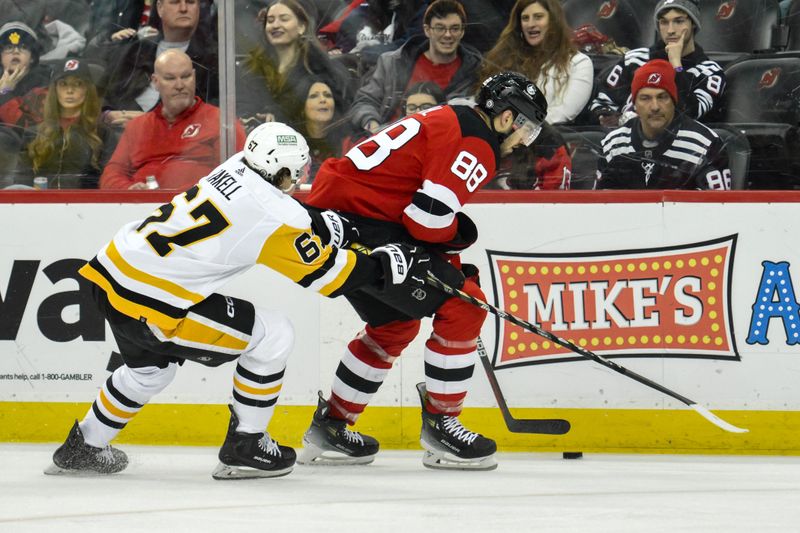 Apr 2, 2024; Newark, New Jersey, USA; New Jersey Devils defenseman Kevin Bahl (88) skates with the puck while being defended by Pittsburgh Penguins right wing Rickard Rakell (67) during the second period at Prudential Center. Mandatory Credit: John Jones-USA TODAY Sports