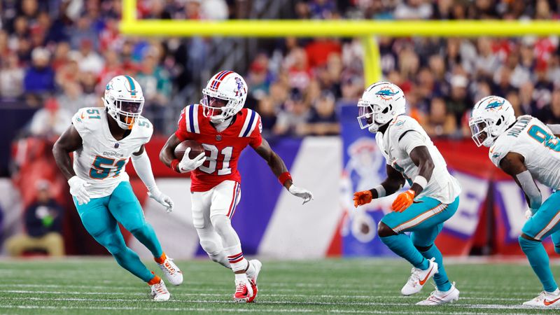 New England Patriots wide receiver Demario Douglas (81) threads through the Miami Dolphins defensive line during the first half of an NFL football game, Sunday, Sept. 17, 2023, in Foxborough, Mass. (AP Photo/Michael Dwyer)