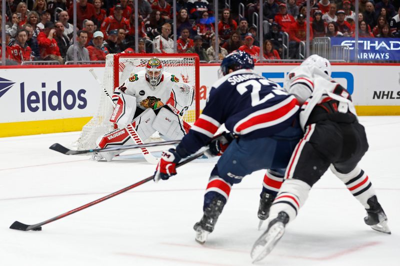 Mar 9, 2024; Washington, District of Columbia, USA; Washington Capitals center Michael Sgarbossa (23) skates with the puck on Chicago Blackhawks goaltender Petr Mrazek (34) as Blackhawks center Ryan Donato (8) defends in the first period at Capital One Arena. Mandatory Credit: Geoff Burke-USA TODAY Sports