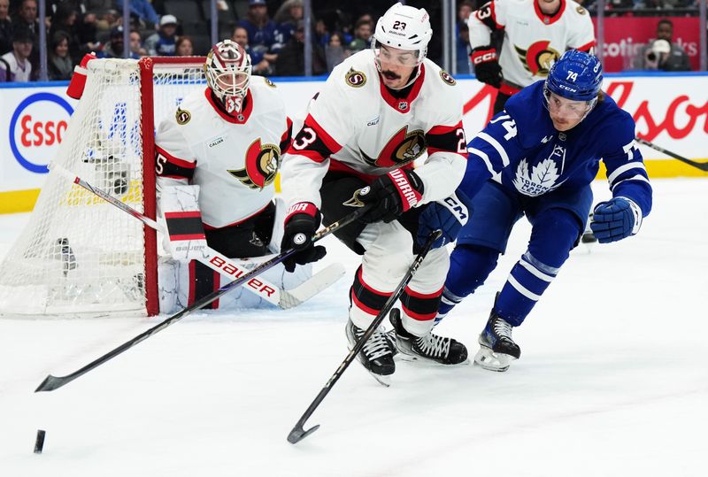 Nov 12, 2024; Toronto, Ontario, CAN; Ottawa Senators defenseman Travis Hamonic (23) battles for the puck with Toronto Maple Leafs center Bobby McMann (74) during the first period at Scotiabank Arena. Mandatory Credit: Nick Turchiaro-Imagn Images