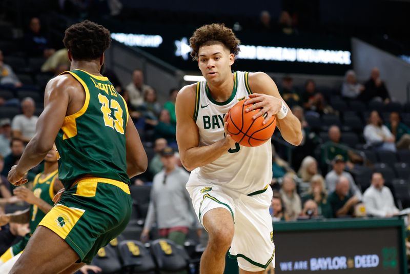 Dec 10, 2025; Waco, Texas, USA;  Baylor Bears guard Dan Skillings Jr. (0) drives to the basket against Norfolk State Spartans forward Keyontae Lewis (23) during the first half at Paul and Alejandra Foster Pavilion. Mandatory Credit: Chris Jones-Imagn Images
