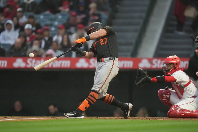 Apr 22, 2024; Anaheim, California, USA; Baltimore Orioles catcher James McCann (27) follows through on a solo home run in the second inning against the Los Angeles Angels at Angel Stadium. Mandatory Credit: Kirby Lee-USA TODAY Sports