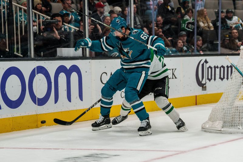 Jan 18, 2023; San Jose, California, USA; San Jose Sharks defenseman Erik Karlsson (65) and Dallas Stars left wing Joel Kiviranta (25) battle for the puck behind the net during the first period at SAP Center at San Jose. Mandatory Credit: Neville E. Guard-USA TODAY Sports