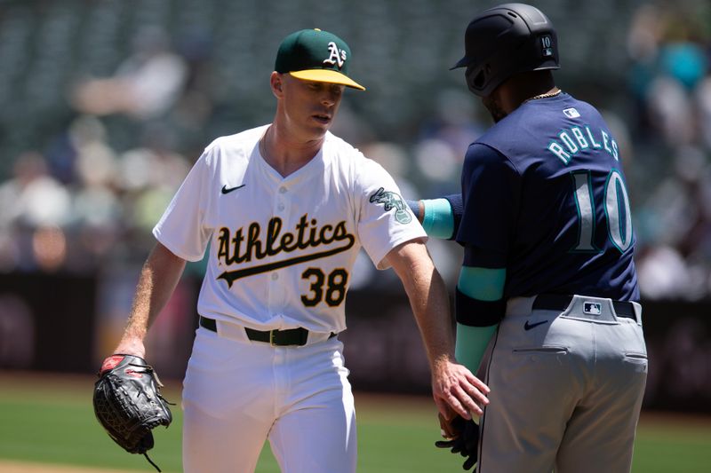 Jun 6, 2024; Oakland, California, USA; Oakland Athletics starting pitcher JP Sears (38) greets Seattle Mariners left fielder Victor Robles (10) after hitting him with a pitch during the third inning at Oakland-Alameda County Coliseum. Mandatory Credit: D. Ross Cameron-USA TODAY Sports