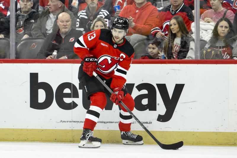 Feb 24, 2024; Newark, New Jersey, USA; New Jersey Devils center Nico Hischier (13) passes the puck during the second period against the Montreal Canadiens at Prudential Center. Mandatory Credit: John Jones-USA TODAY Sports