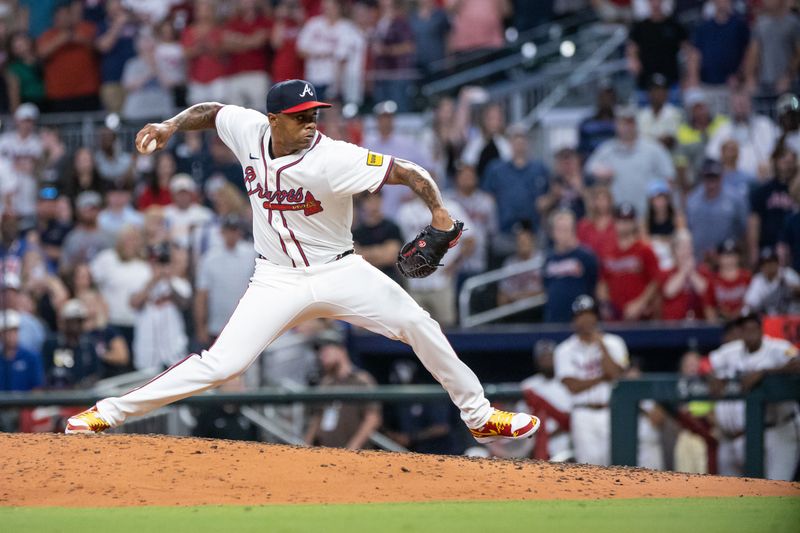 Aug 22, 2024; Cumberland, Georgia, USA; Atlanta Braves pitcher Raisel Iglesias (26) pitches the ball against Philadelphia Phillies during the ninth inning at Truist Park. Mandatory Credit: Jordan Godfree-USA TODAY Sports