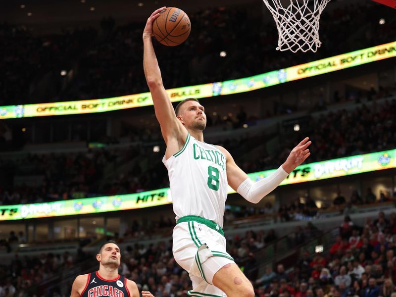 CHICAGO, ILLINOIS - NOVEMBER 29: Kristaps Porzingis #8 of the Boston Celtics dunks the ball past Nikola Vucevic #9 of the Chicago Bulls during the first quarter of the Emirates NBA Cup game at the United Center on November 29, 2024 in Chicago, Illinois. NOTE TO USER: User expressly acknowledges and agrees that, by downloading and or using this photograph, User is consenting to the terms and conditions of the Getty Images License Agreement.  (Photo by Luke Hales/Getty Images)