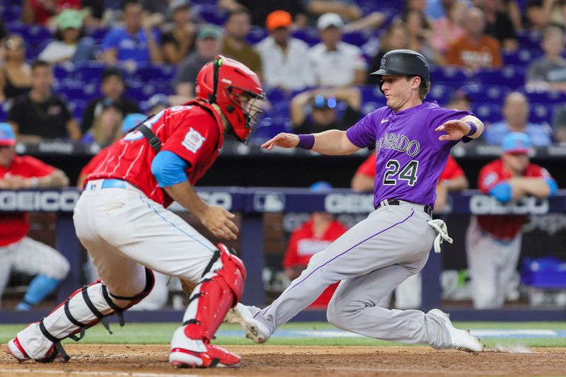 Jul 22, 2023; Miami, Florida, USA; Colorado Rockies third baseman Ryan McMahon (24) slides into home and scores against the Miami Marlins during the ninth inning at loanDepot Park. Mandatory Credit: Sam Navarro-USA TODAY Sports