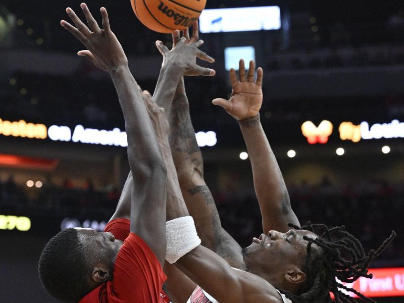 Jan 13, 2024; Louisville, Kentucky, USA;  Louisville Cardinals guard Mike James (0) draws a foul while shooting from North Carolina State Wolfpack forward Mohamed Diarra (23) during the second half at KFC Yum! Center. Mandatory Credit: Jamie Rhodes-USA TODAY Sports