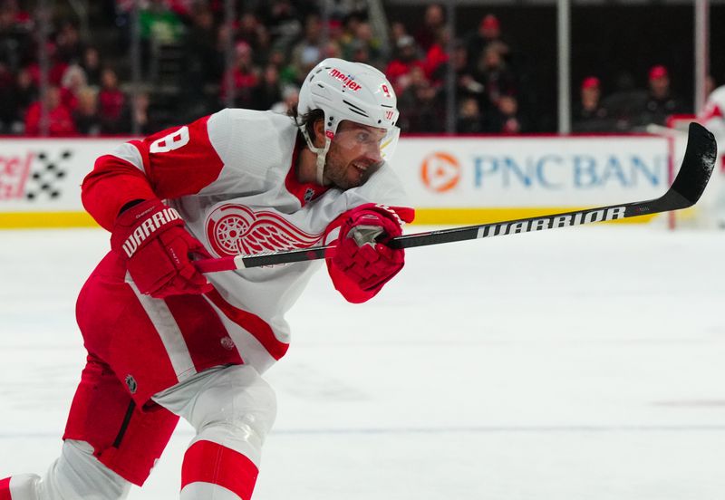 Jan 19, 2024; Raleigh, North Carolina, USA;  Detroit Red Wings defenseman Ben Chiarot (8) takes a shot against the Carolina Hurricanes during the second period at PNC Arena. Mandatory Credit: James Guillory-USA TODAY Sports