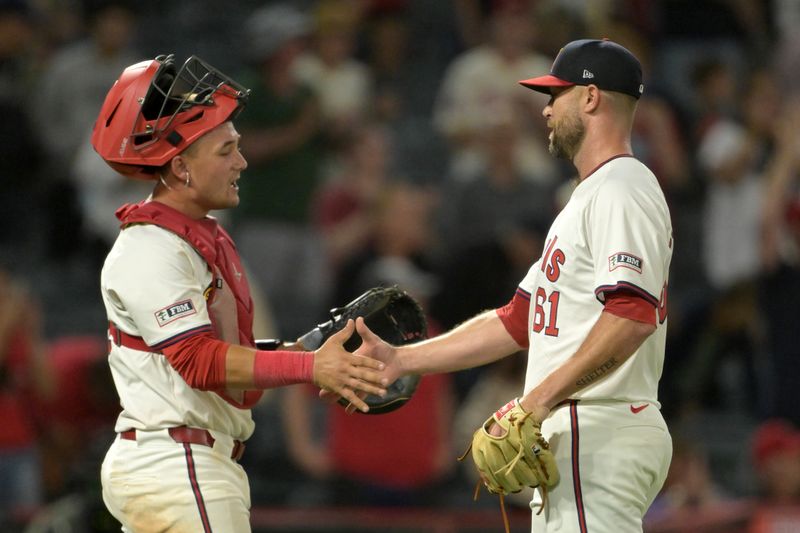 Jul 30, 2024; Anaheim, California, USA; Los Angeles Angels catcher Matt Thaiss (21) congratulates relief pitcher Hunter Strickland (61) after a save in the ninth inning against the Colorado Rockies at Angel Stadium. Mandatory Credit: Jayne Kamin-Oncea-USA TODAY Sports