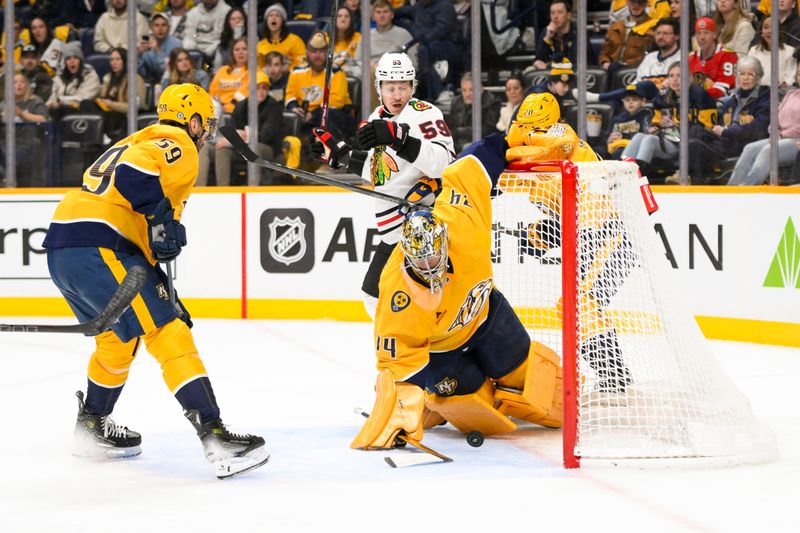 Jan 16, 2025; Nashville, Tennessee, USA;  Chicago Blackhawks defenseman Alec Martinez (25) shoots from the blue and with funny bounces scores past Nashville Predators goaltender Juuse Saros (74) during the second period at Bridgestone Arena. Mandatory Credit: Steve Roberts-Imagn Images