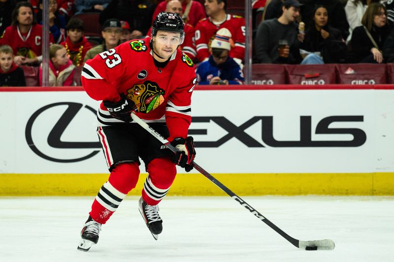 Feb 9, 2024; Chicago, Illinois, USA; Chicago Blackhawks center Philipp Kurashev (23) skates with the puck against the New York Rangers during the second period at the United Center. Mandatory Credit: Daniel Bartel-USA TODAY Sports