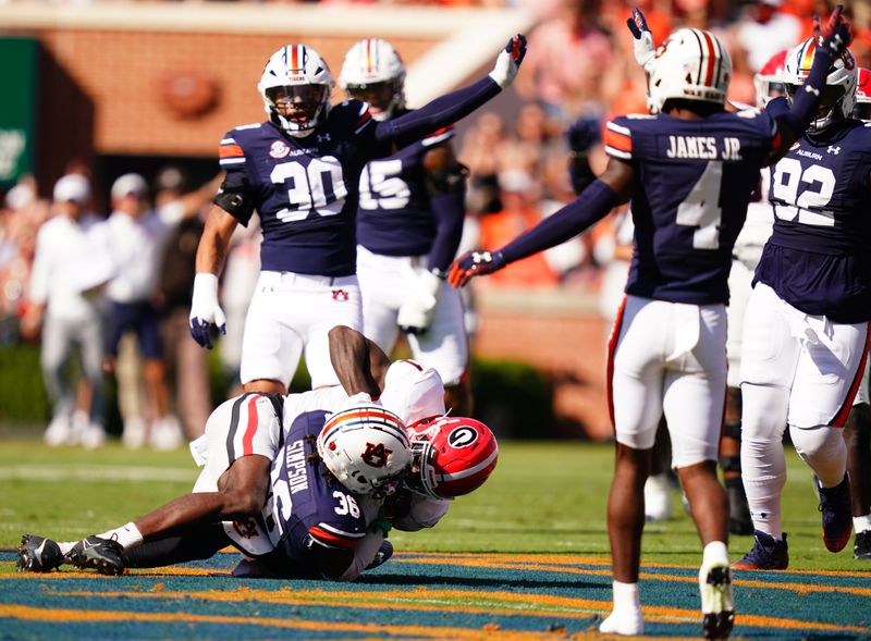 Sep 30, 2023; Auburn, Alabama, USA; Auburn Tigers cornerback Jaylin Simpson (36) pulls down an interception over Georgia Bulldogs wide receiver Marcus Rosemy-Jacksaint (1) during the first quarter at Jordan-Hare Stadium. Mandatory Credit: John David Mercer-USA TODAY Sports