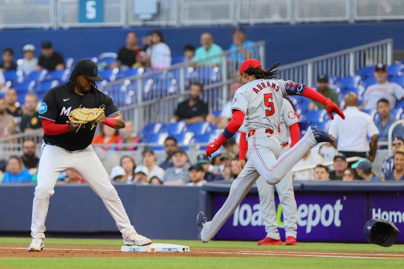 Apr 26, 2024; Miami, Florida, USA; Miami Marlins first baseman Josh Bell (9) catches a baseball from starting pitcher Anthony Maldonado (not pictured) to retire Washington Nationals shortstop CJ Abrams (5) at first base during the first inning at loanDepot Park. Mandatory Credit: Sam Navarro-USA TODAY Sports