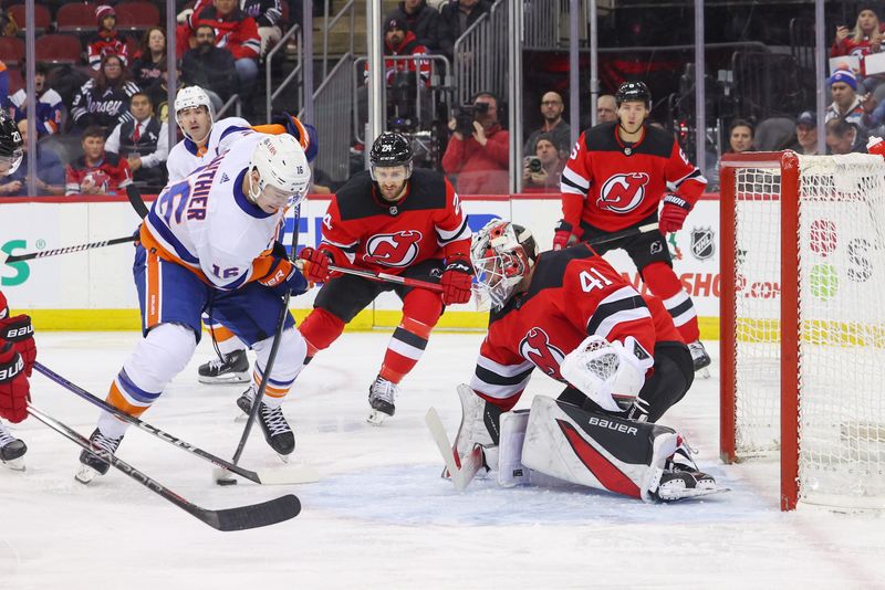 Nov 28, 2023; Newark, New Jersey, USA; New York Islanders right wing Julien Gauthier (16) shoots the puck towards the net of New Jersey Devils goaltender Vitek Vanecek (41) during the first period at Prudential Center. Mandatory Credit: Ed Mulholland-USA TODAY Sports