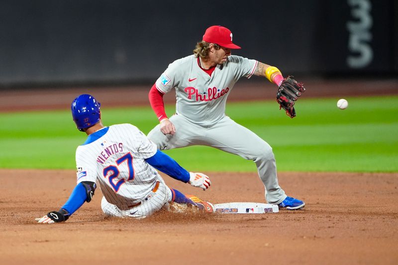 Sep 22, 2024; New York City, New York, USA;  New York Mets third baseman Mark Vientos (27) slides into second base with a double ahead of the throw received by Philadelphia Phillies second baseman Bryson Stott (5) during the second inning at Citi Field. Mandatory Credit: Gregory Fisher-Imagn Images