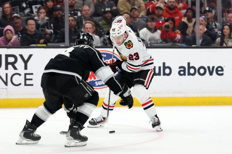 Mar 19, 2024; Los Angeles, California, USA;  Chicago Blackhawks center Philipp Kurashev (23) controls the puck against Los Angeles Kings defenseman Drew Doughty (8) during the second period at Crypto.com Arena. Mandatory Credit: Kiyoshi Mio-USA TODAY Sports