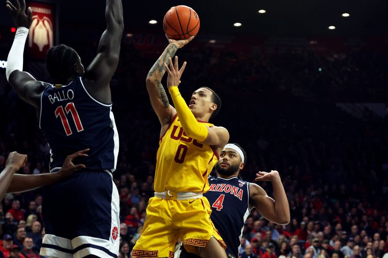 Jan 17, 2024; Tucson, Arizona, USA; USC Trojans guard Kobe Johnson (0) drives to the net against Arizona Wildcats center Oumar Ballo (11) during the first half at McKale Center. Mandatory Credit: Zachary BonDurant-USA TODAY Sports