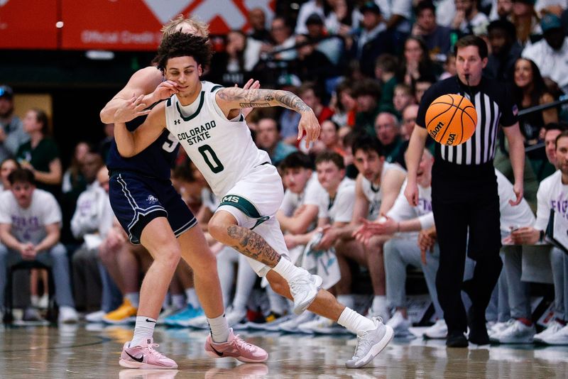 Mar 1, 2025; Fort Collins, Colorado, USA; Colorado State Rams guard Kyan Evans (0) is fouled by Utah State Aggies guard Jordy Barnes (5) in the second half at Moby Arena. Mandatory Credit: Isaiah J. Downing-Imagn Images