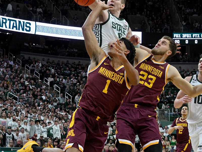 Jan 28, 2025; East Lansing, Michigan, USA;  Michigan State Spartans forward Jaxon Kohler (0) blocks a shot by Minnesota Golden Gophers guard Isaac Asuma (1) during the first half at Jack Breslin Student Events Center. Mandatory Credit: Dale Young-Imagn Images
