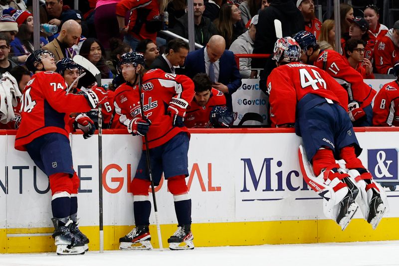 Jan 4, 2025; Washington, District of Columbia, USA; Washington Capitals head coach Spencer Carbery (M) looks at a video replay with Capitals goaltender Logan Thompson (48) during a goal challenge review against the New York Rangers in the second period at Capital One Arena. Mandatory Credit: Geoff Burke-Imagn Images