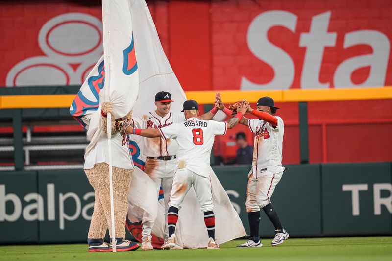 Apr 12, 2023; Cumberland, Georgia, USA; Atlanta Braves outfielders Sam Hilliard Eddie Rosario and Ronald Acuna Jr. react after defeating the Cincinnati Reds at Truist Park. Mandatory Credit: Dale Zanine-USA TODAY Sports