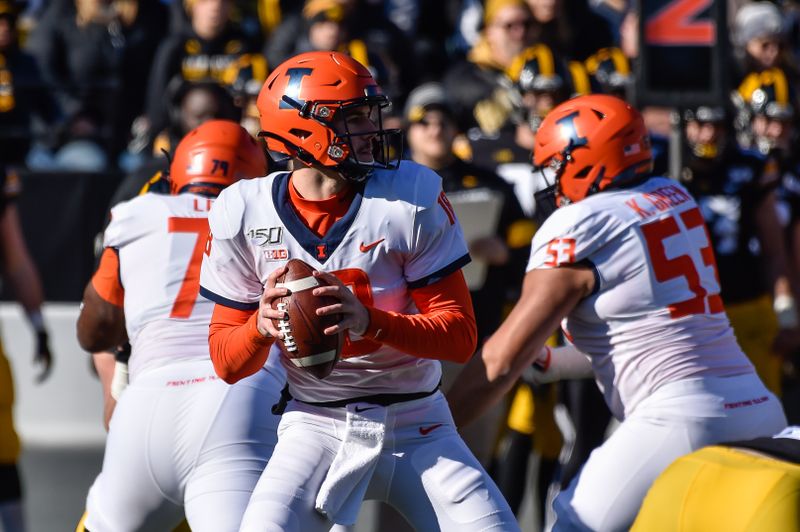 Nov 23, 2019; Iowa City, IA, USA; Illinois Fighting Illini quarterback Brandon Peters (18) drops back to throw a pass against the Iowa Hawkeyes during the first quarter at Kinnick Stadium. Mandatory Credit: Jeffrey Becker-USA TODAY Sports