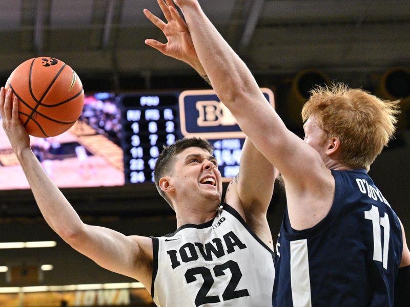 Feb 27, 2024; Iowa City, Iowa, USA; Iowa Hawkeyes forward Patrick McCaffery (22) goes to the basket as Penn State Nittany Lions forward Leo O'Boyle (11) defends during the second half at Carver-Hawkeye Arena. Mandatory Credit: Jeffrey Becker-USA TODAY Sports