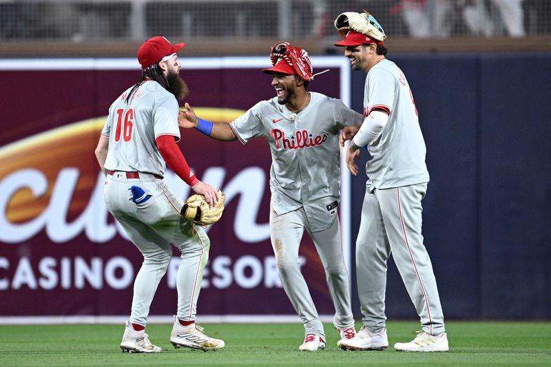 Apr 26, 2024; San Diego, California, USA; Philadelphia Phillies center fielder Johan Rojas (center) celebrates on the field with right fielder Nick Castellanos (8) and left fielder Brandon Marsh (16) after defeating the San Diego Padres at Petco Park. Mandatory Credit: Orlando Ramirez-USA TODAY Sports