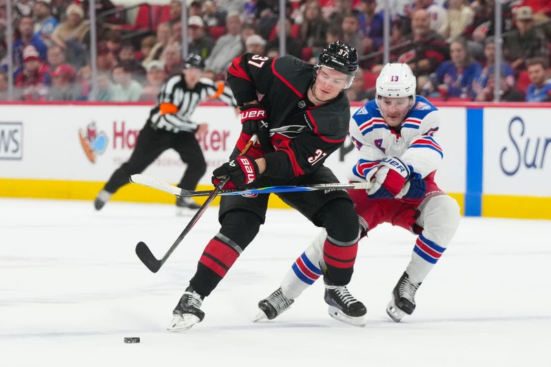 Nov 26, 2025; Raleigh, North Carolina, USA; Carolina Hurricanes right wing Andrei Svechnikov (37) skates with the puck against New York Rangers left wing Alexis Lafrenière (13) during the third period t Lenovo Center. Mandatory Credit: James Guillory-Imagn Images