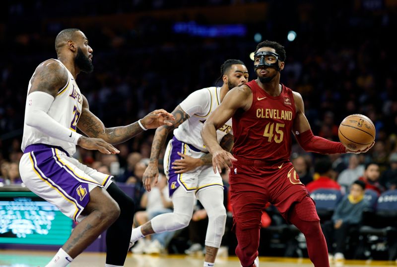 LOS ANGELES, CALIFORNIA - APRIL 6: Donovan Mitchell #45 of the Cleveland Cavaliers looks to pass the ball as he double teamed by LeBron James #23 and D'Angelo Russell #1 of the Los Angeles Lakers during the first half at Crypto.com Arena on April 6, 2024 in Los Angeles, California. NOTE TO USER: User expressly acknowledges and agrees that, by downloading and or using this photograph, User is consenting to the terms and conditions of the Getty Images License Agreement. (Photo by Kevork Djansezian/Getty Images)