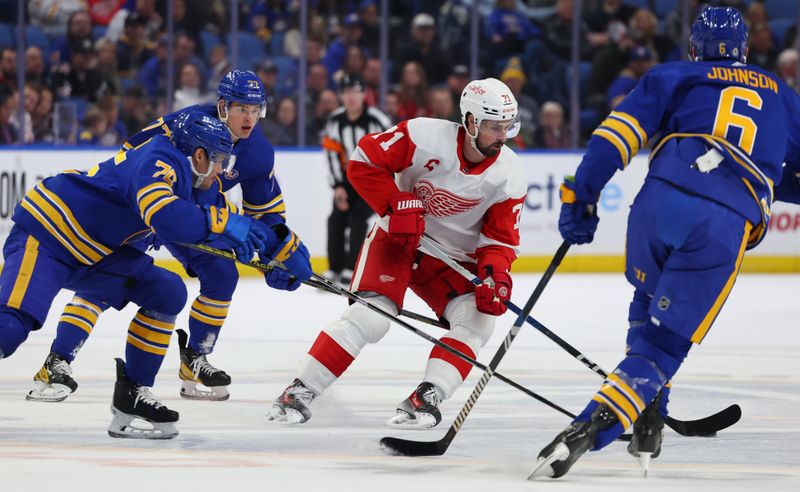 Dec 5, 2023; Buffalo, New York, USA;  Detroit Red Wings center Dylan Larkin (71) carries the puck as Buffalo Sabres defenseman Connor Clifton (75) defends during the first period at KeyBank Center. Mandatory Credit: Timothy T. Ludwig-USA TODAY Sports