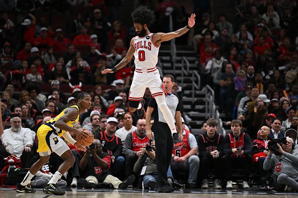 CHICAGO, ILLINOIS - DECEMBER 28:  Coby White #0 of the Chicago Bulls jumps over Bennedict Mathurin #00 of the Indiana Pacers in the second half on December 28, 2023 at the United Center in Chicago, Illinois. Indiana defeated Chicago 120-104.   NOTE TO USER: User expressly acknowledges and agrees that, by downloading and or using this photograph, User is consenting to the terms and conditions of the Getty Images License Agreement.  (Photo by Jamie Sabau/Getty Images)