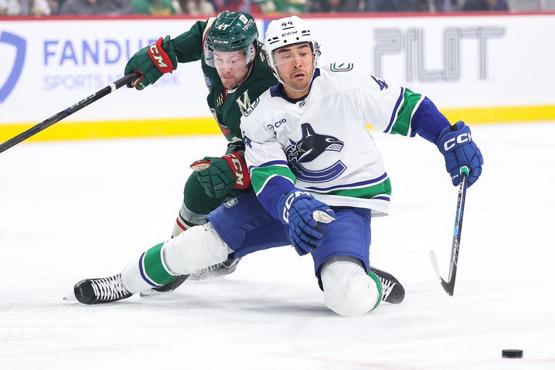 Dec 3, 2024; Saint Paul, Minnesota, USA; Vancouver Canucks left wing Kiefer Sherwood (44) skates with the puck alongside Minnesota Wild defenseman Declan Chisholm (47) during the first period at Xcel Energy Center. Mandatory Credit: Matt Krohn-Imagn Images