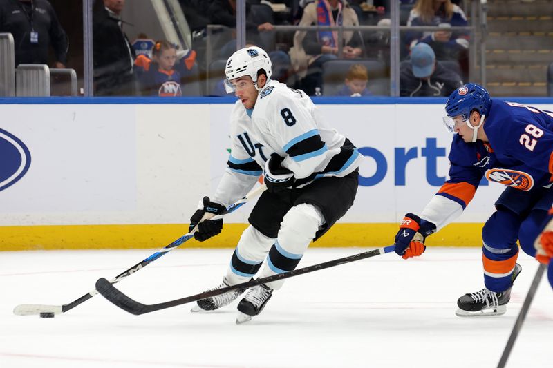 Oct 10, 2024; Elmont, New York, USA; Utah Hockey Club center Nick Schmaltz (8) skates with the puck against New York Islanders defenseman Alexander Romanov (28) during the first period at UBS Arena. Mandatory Credit: Brad Penner-Imagn Images