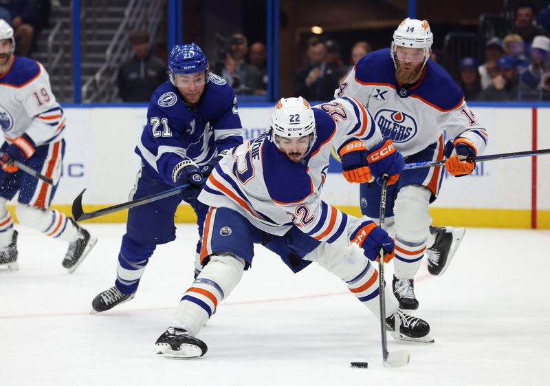 Nov 20, 2025; Tampa, Florida, USA;  Edmonton Oilers center Matt Savoie (22) defends the puck as Tampa Bay Lightning center Brayden Point (21) skates during the first period at Benchmark International Arena. Mandatory Credit: Kim Klement Neitzel-Imagn Images